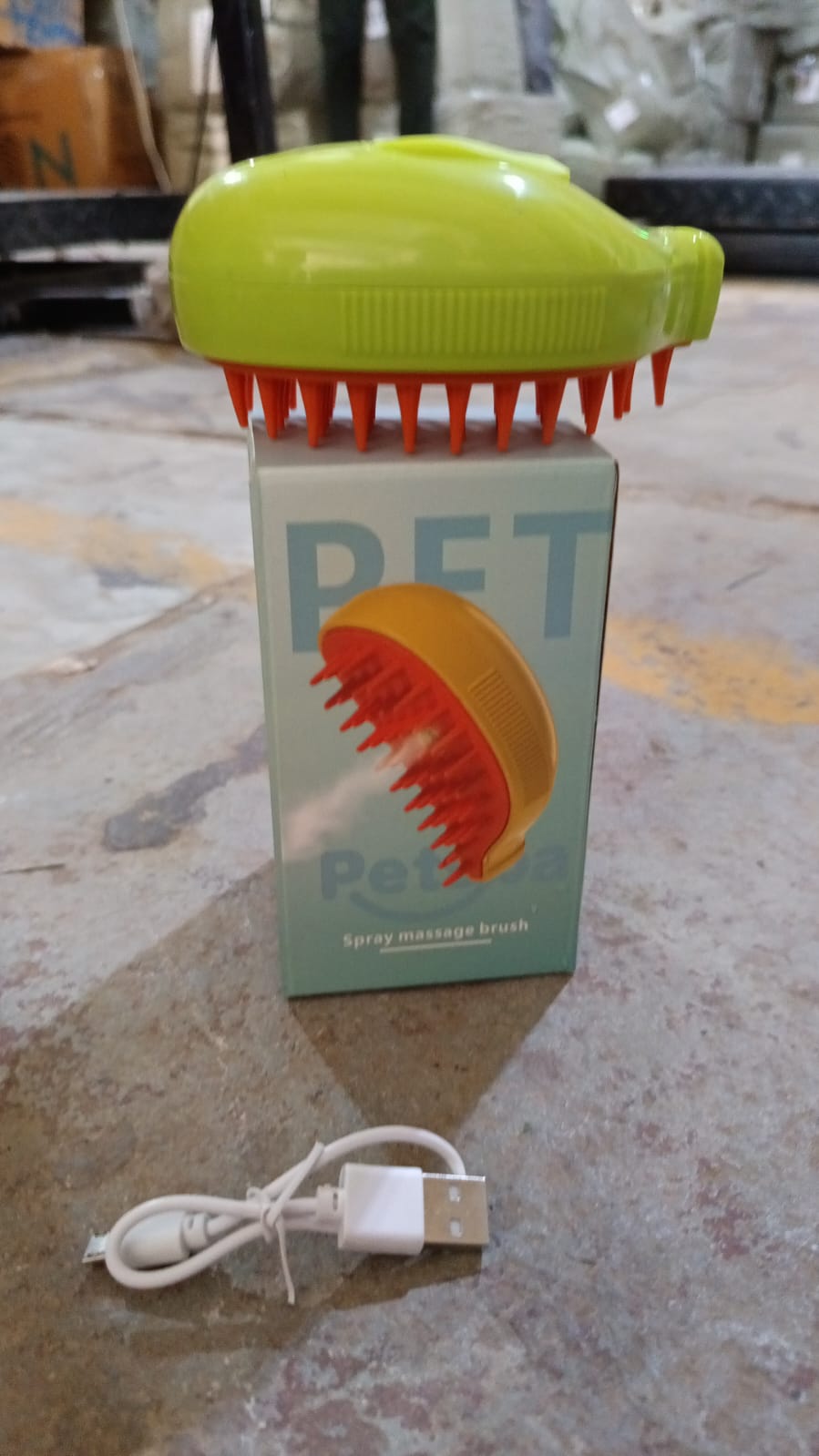Steam pet brush with its retail box and USB charging cable